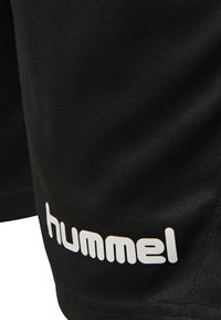 Sorte atletiske shorts lavet af glat stof, med et hvidt "hummel" logo på den nederste side. Enkel design uden yderligere mønstre.