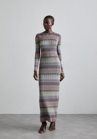 Rochie lungă, ajustată, cu mâneci lungi, dintr-un tricot cu model ondulat, având culorile roz, verde și alb. Lungime până la podea, cu tiv în undă.