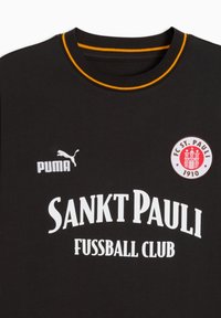 Sort bomulds-T-shirt med korte ærmer, med rund halsudskæring med gule accenter, FC St. Pauli-logo og fed hvid tekst.