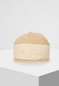 Beanie lavorato a maglia in beige, con un top testurizzato e una fascia bianca intrecciata. Forma arrotondata con una vestibilità aderente, realizzato in materiale morbido.