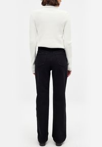 Valge ribaga pikakä sleeves top, millele on sobitatud kõrge vöökoht ja mustad laiad püksid. Pükstel on tagakotid ja sobituv vöökoht.