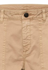 Beige chinos med en glat tekstur, der har en frontknaplukning, sømdetaljer og standard lommer.