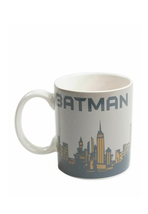 White ceramic mug with "BATMAN" text and a gold and gray city skyline design around its exterior.