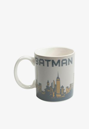 White ceramic mug with "BATMAN" text and a gold and gray city skyline design around its exterior.