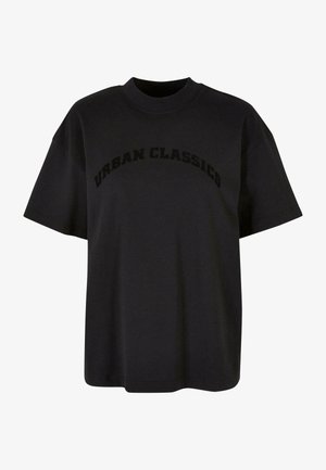 Juodas medvilninis marškinėliai su laisvu siluetu, trumpomis rankovėmis ir apvaliu kaklu, su užrašu "URBAN CLASSICS" ryškiu šriftu priešakinėje pusėje.