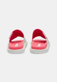 Sandali a scivolo con esterno bianco, interno rosa, design aperto sul retro e suola bianca texturizzata. Presentano una chiusura in velcro per la regolabilità.