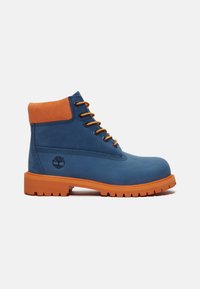 Stivaletti blu in pelle con collo in suede arancione, occhielli in metallo e suola in gomma arancione con motivo antiscivolo. Logo ad albero sul lato.
