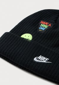 Fekete bordás kötött sapka színes "Have a Nike Day" felirattal, neon zöld mosolygós arccal és fehér hímzett Nike logóval a szegélyen.