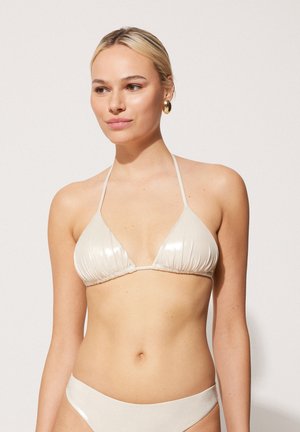 Trójkątny biustonosz bikini w jasnym beżu z plisowanym wzorem, regulowanymi ramiączkami i dopasowanymi majtkami bikini. Gładka, błyszcząca tekstura.