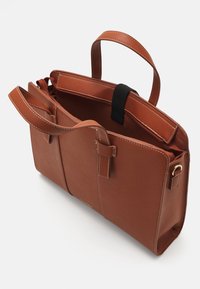 Sac en cuir marron avec deux poignées, poche intérieure et couture contrastante. Forme rectangulaire avec une ouverture en haut et une fermeture sécurisée.