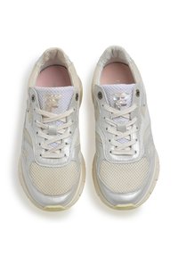 Kevyet lenkkarit, joissa on verkko-yläosa off-white ja hopean värissä, sävyyn sopivat nauhat ja heijastava yksityiskohta kengän kielellä.