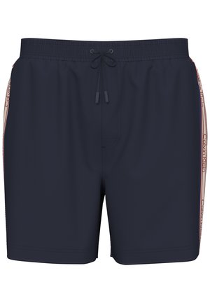 Μπλε σκούρο ανδρικό μαγιό με ελαστική μέση, κορδόνι στο μπροστινό μέρος και πλευρικές ρίγες με το λογότυπο Calvin Klein σε κόκκινο και λευκό.