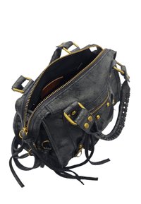 Sac à main en cuir noir avec quincaillerie en ton doré, présentant des zips, des clous et une bandoulière tressée. Comprend un intérieur ouvert avec une doublure contrastante.