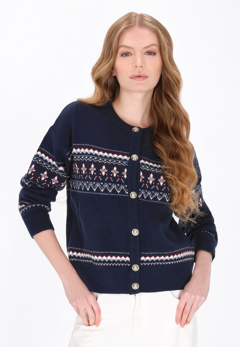 Cardigan bleumarin din material tricotat, cu un model Fair Isle în accente roșii, albe și albastre, și nasturi de culoare auriu.
