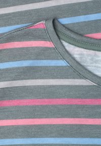 Gros plan d’un tissu gris avec des rayures horizontales roses, bleues, blanches et gris clair, montrant le détail d’un col cousu.