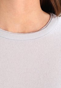 Lichtgrijze pullover met een ronde hals. Gemaakt van een zachte, ribbelstof. Beschikt over een gladde textuur en een strak, eenvoudig ontwerp.