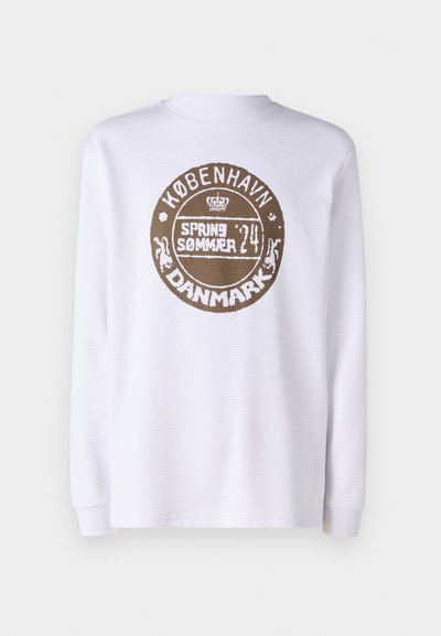 White long-sleeve shirt with textured fabric and ribbed cuffs. Features a round brown graphic print reading "KØBENHAVN SPRING SOMMER 24 DANMARK."