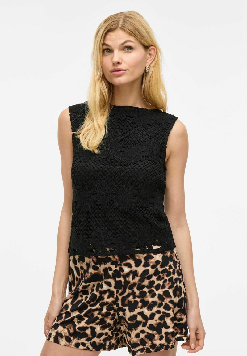 Black sleeveless top with textured floral crochet pattern, rounded neckline, and hemline slightly below waist, paired with leopard print shorts.