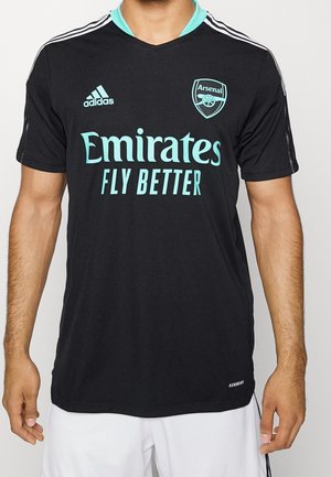Maglia da calcio nera con accenti turchesi, presenta il logo "Arsenal" e il testo "Emirates Fly Better" sul davanti. Realizzata in materiale traspirante.