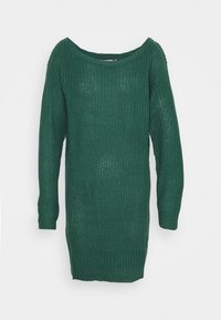 Robe pull en tricot vert avec un large décolleté bateau et des manches longues. La texture est lâche et aérée, créant une silhouette décontractée et relaxée.