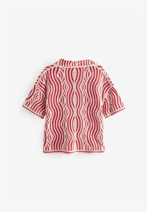 Short-sleeve knit shirt featuring a red and white wavy pattern, textured material, and crew neck design. Distinctive crochet accents.