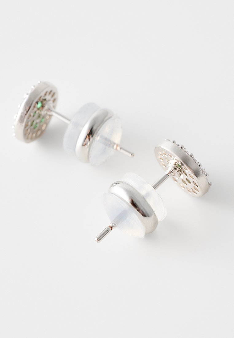 Orecchini a perno color argento con design circolare, caratterizzati da uno sfondo in metallo testurizzato, dettagli con pietre trasparenti e una finitura lucida.
