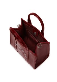 Small red leather handbag with a structured design, two handles, and an open top. Features interior pockets and a logo printed on the front.