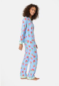 Blaues Pyjama-Set mit Erdbeerprint; Langarm, passende Hose und gestreifte Bündchen. Weicher Stoff mit bequemer Passform, geeignet als Nachtwäsche.