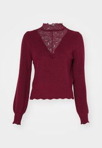 Bordeaux sweater met een kanten paneel en een golvende zoom. Lange mouwen met ribgebreide manchetten. Heeft een V-hals ontwerp en een gestructureerde brei.