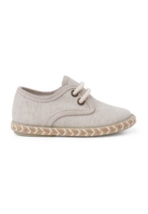 Chaussure en toile beige à découpe basse, avec un bout rond, deux œillets, des lacets blancs et une semelle en jute tissée. Texture douce et design épuré.
