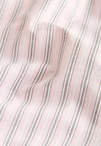 Tissu rose avec de fines rayures blanches et brunes verticales, présenté avec des plis doux et des détails de texture.