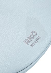 Svijetloplava teksturirana koža s utisnutim srebrnim logotipom "RKO RYŁKO." Glatka površina i zaobljeni detalji, naglašavajući moderni dizajn.