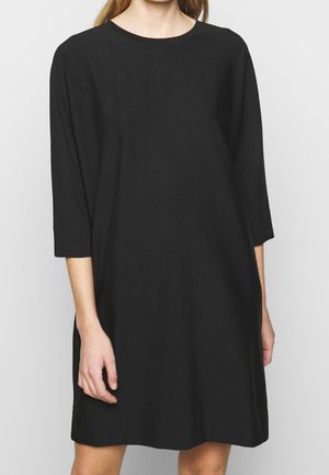 Schwarzes Shift-Kleid mit dreiviertel Ärmeln, rundem Ausschnitt und lockerem Schnitt. Hergestellt aus leichtem Stoff mit glatter Oberfläche.