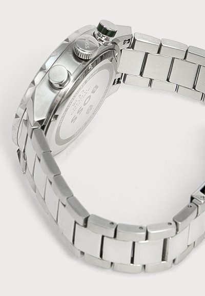 Montre-bracelet Boss en acier inoxydable avec un bracelet métallique à maillons, des boutons latéraux et un logo visible gravé au dos.