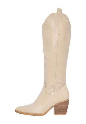 Bota de cuero beige hasta la rodilla con puntera afilada, detalles de costura y un tacón de madera estriada. Textura suave con acentos mínimos.