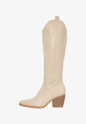 Bota de cuero beige hasta la rodilla con puntera afilada, detalles de costura y un tacón de madera estriada. Textura suave con acentos mínimos.