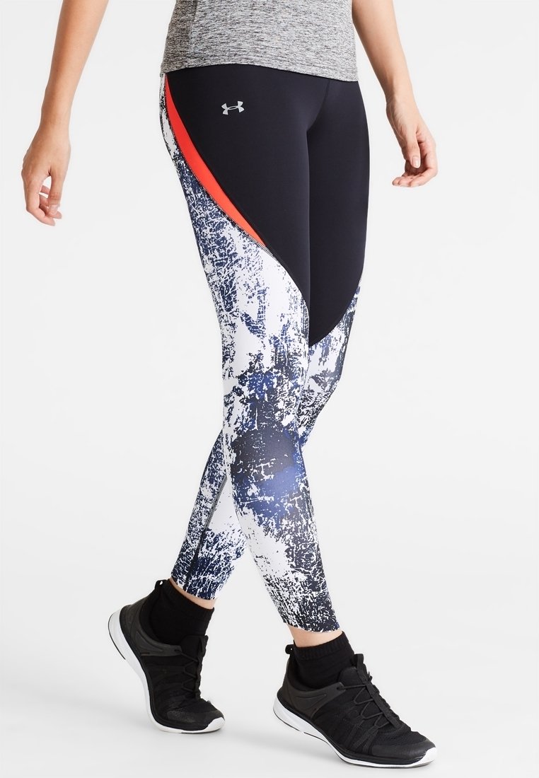 Leggings stampati in bianco e nero con accenti blu navy e rossi, caratterizzati da un design aderente e materiale morbido e elasticizzato. Logo Under Armour visibile.