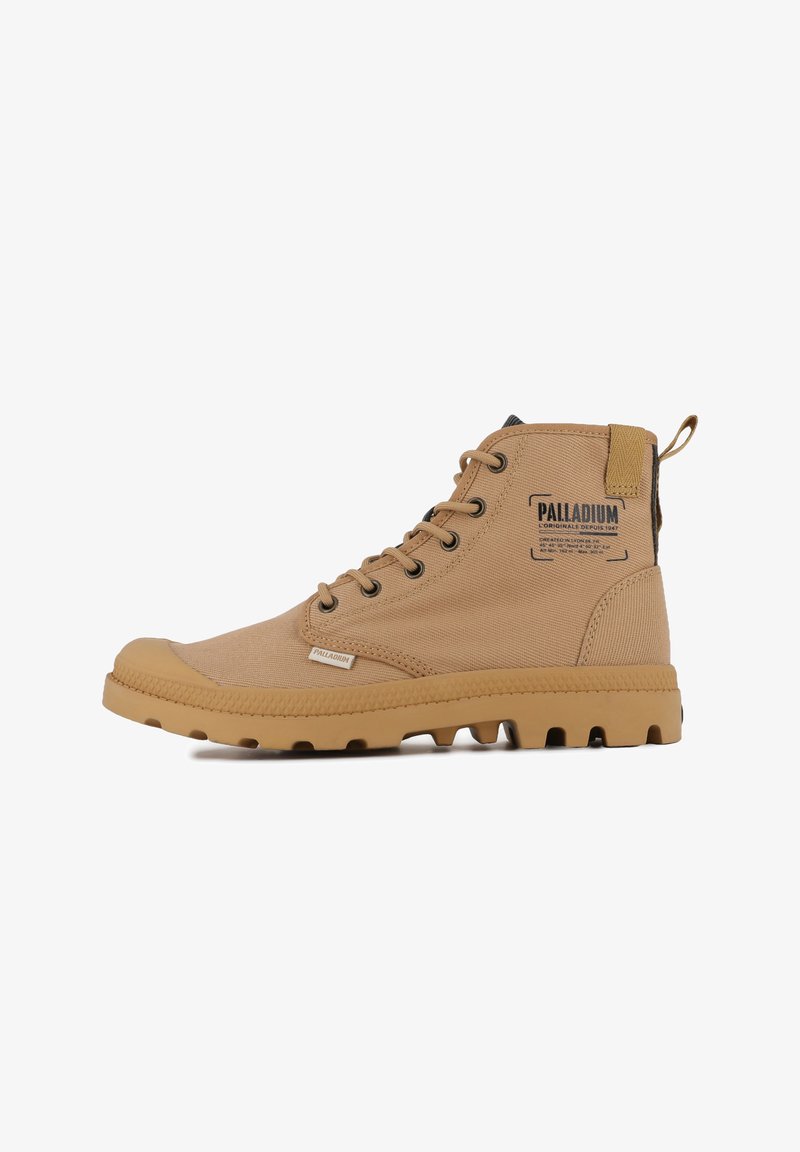 Stivali alto beige realizzati in tessuto, con occhielli in metallo, una suola in gomma con motivo e un piccolo etichetta con logo sul lato.