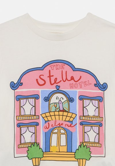 Biele tričko s farebnou ilustráciou kresleného hotela s ružovými a modrými akcentmi, veľkými oknami a privítacou správou.