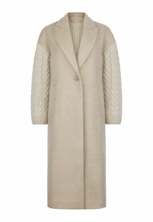 Beige lang frakke med en skræddersyet design, der har kabelstrik teksturerede ærmer, lukning med en enkelt knap og to forlommer.