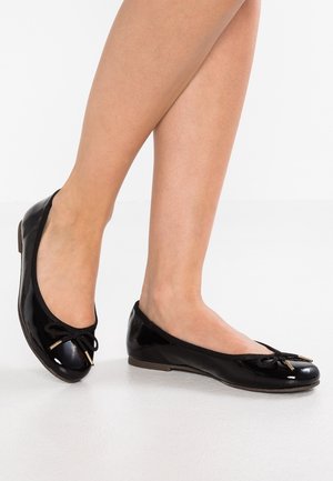 Black patent leather ballet flats featuring a rounded toe, a decorative bow on the front, and a flat sole with a subtle heel.