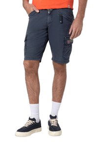 Navy cargo shorts made of cotton, featuring side pockets, a partially zippered front, and contrasting stitching details. Worn with sneakers.