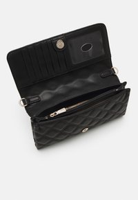 Portafoglio trapuntato nero con finitura testurizzata, hardware in argento, slot per identificazione, più slot per carte e scomparto con zip.
