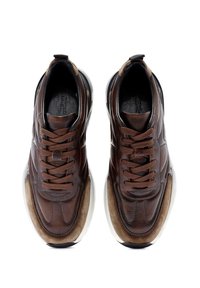 Zapatillas de cuero marrón con cordones marrones, paneles texturizados y una suela de goma blanca. Sutiles acentos en el diseño añaden profundidad.