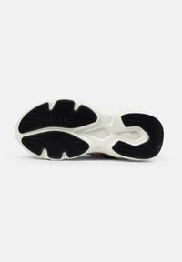 Semelle de sneaker en noir et blanc avec un motif texturé, affichant un logo de marque proéminent et un design sculpté pour l'adhérence.