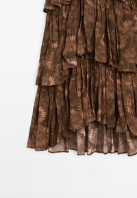 Gonna a strati marrone realizzata in un tessuto leggero e texturizzato, caratterizzata da un motivo floreale in tonalità più chiare. Il design arricciato aggiunge profondità.
