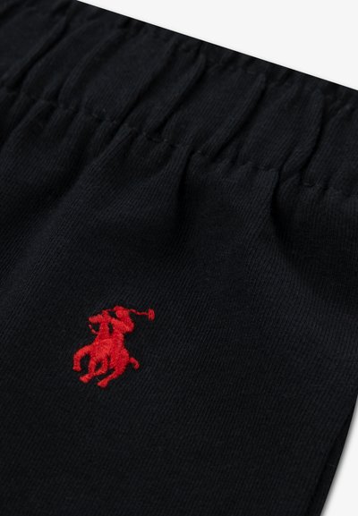 Μαύρο ριμπ ύφασμα με ελαστική μέση και έντονο κόκκινο κεντητό λογότυπο παίκτη πόλο πάνω σε άλογο.