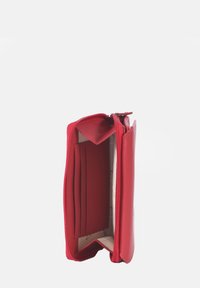 Red leather wallet with a zip closure, featuring multiple card slots and a compartment, smooth texture, and an interior pattern in cream.