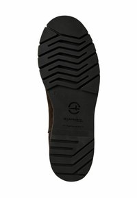 Semelle en caoutchouc noir avec un motif de tread en zigzag profond, présentant un logo circulaire et l'inscription "Fabriqué au Portugal". Cuir nubuck visible sur le bord.
