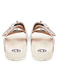 Beige sandaler med en tekstureret overdel, justerbare remme og en polstret indersål. Hvid sål med et cirkulært logo på fodsengen.